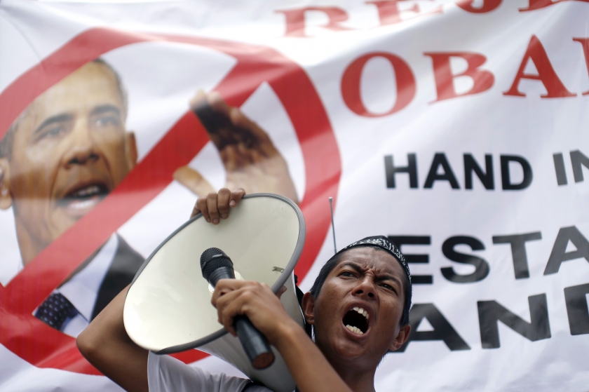 A supporter of the Hizbut Tahrir NGO holds a microphone to a loud-hailer as he shouts slogans against US President Barack Obama's planned visit to Malaysia next week, outside the US embassy in Kuala Lumpur, April 18, 2014. — Reuters pic